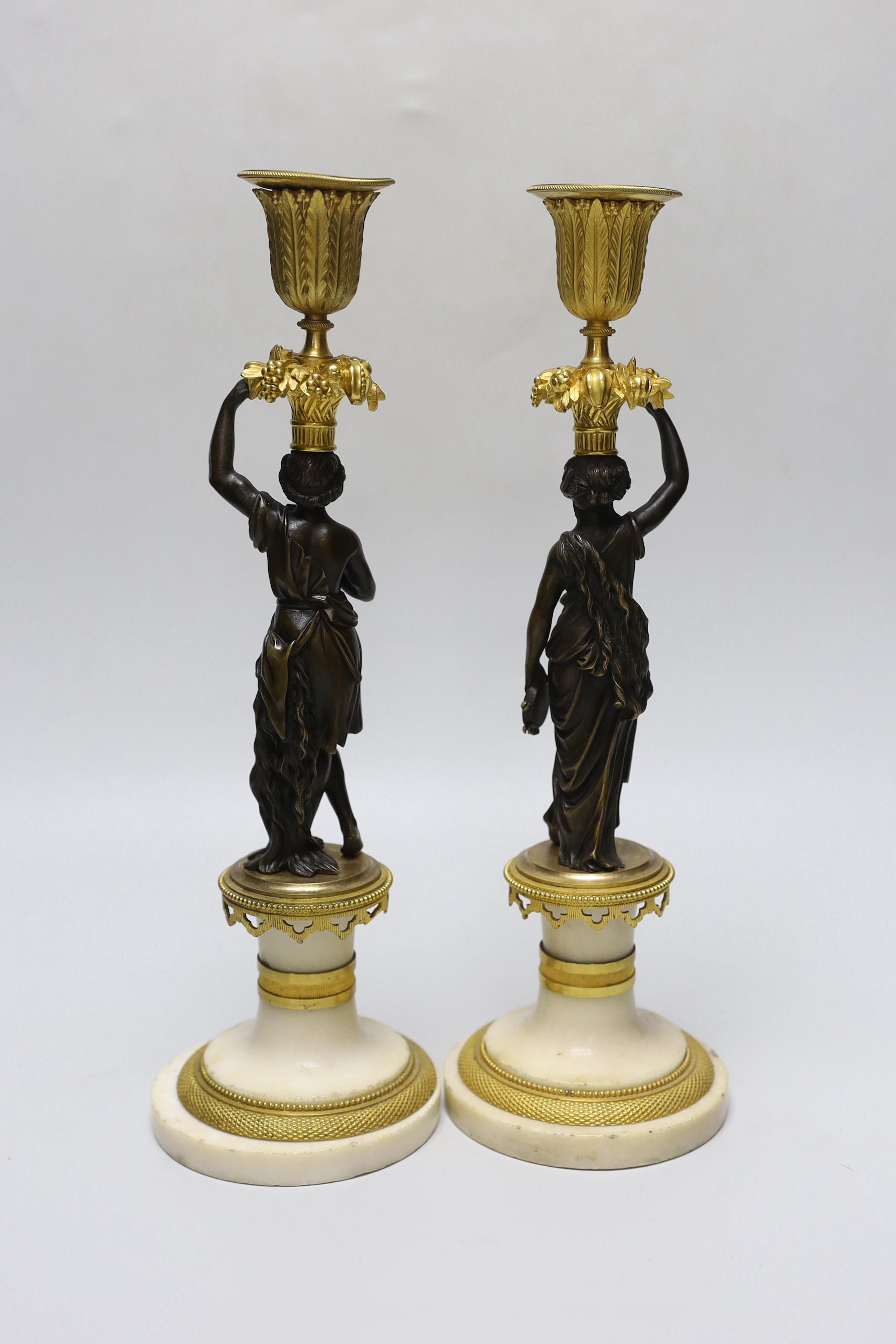 A pair of early 20th century bronze, ormolu and alabaster figural candlesticks, 33cm